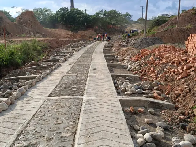 Tramo de la vía en construcción, con las cunetas empedradas a lado y lado