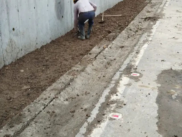 Muro terminado con el canal de aguas al pie del talud