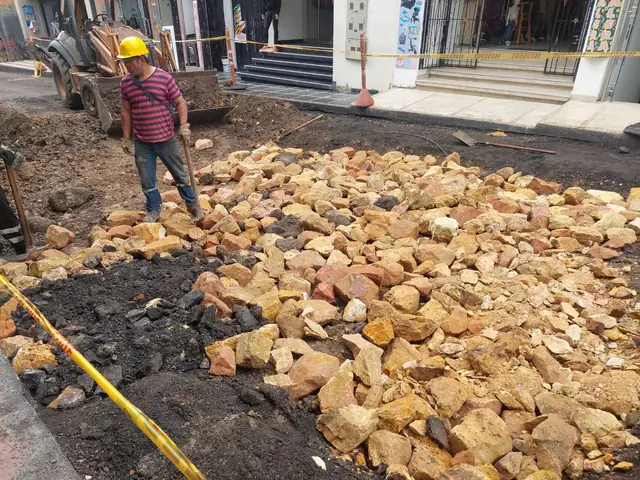 Obrero retirando material de la calzada durante el repacheo de una calle