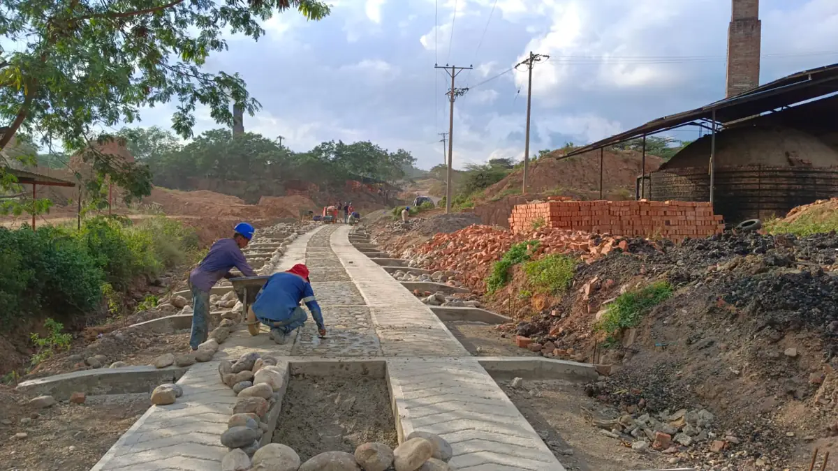 Frente de obra de mejoramiento vial con la placa de concreto y las cunetas en construcción